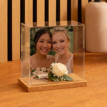 Wedding Memory display case with two women's photo and flowers on a wooden base.