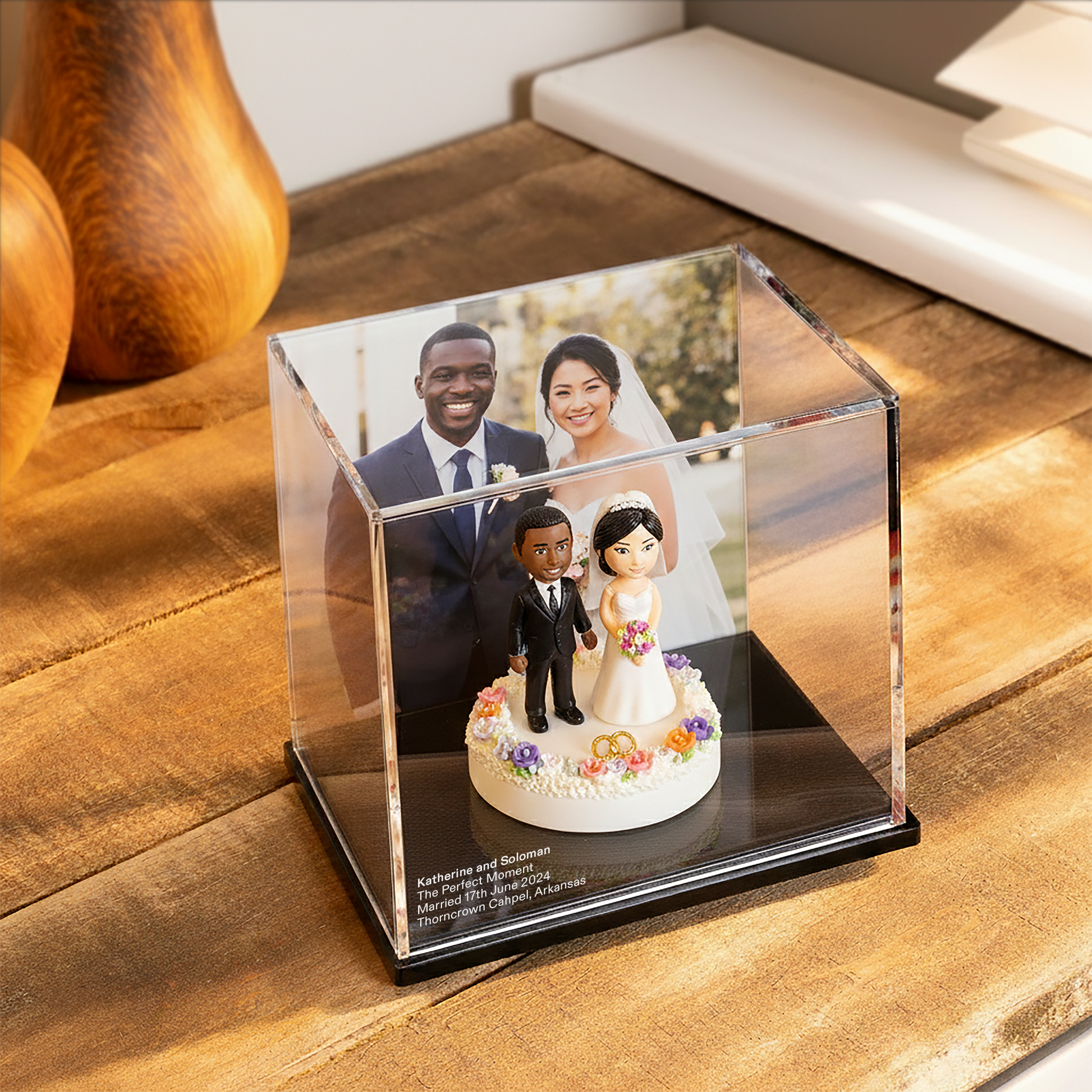 Wedding Memory display case with wedding cake topper and couple photo on a wooden surface