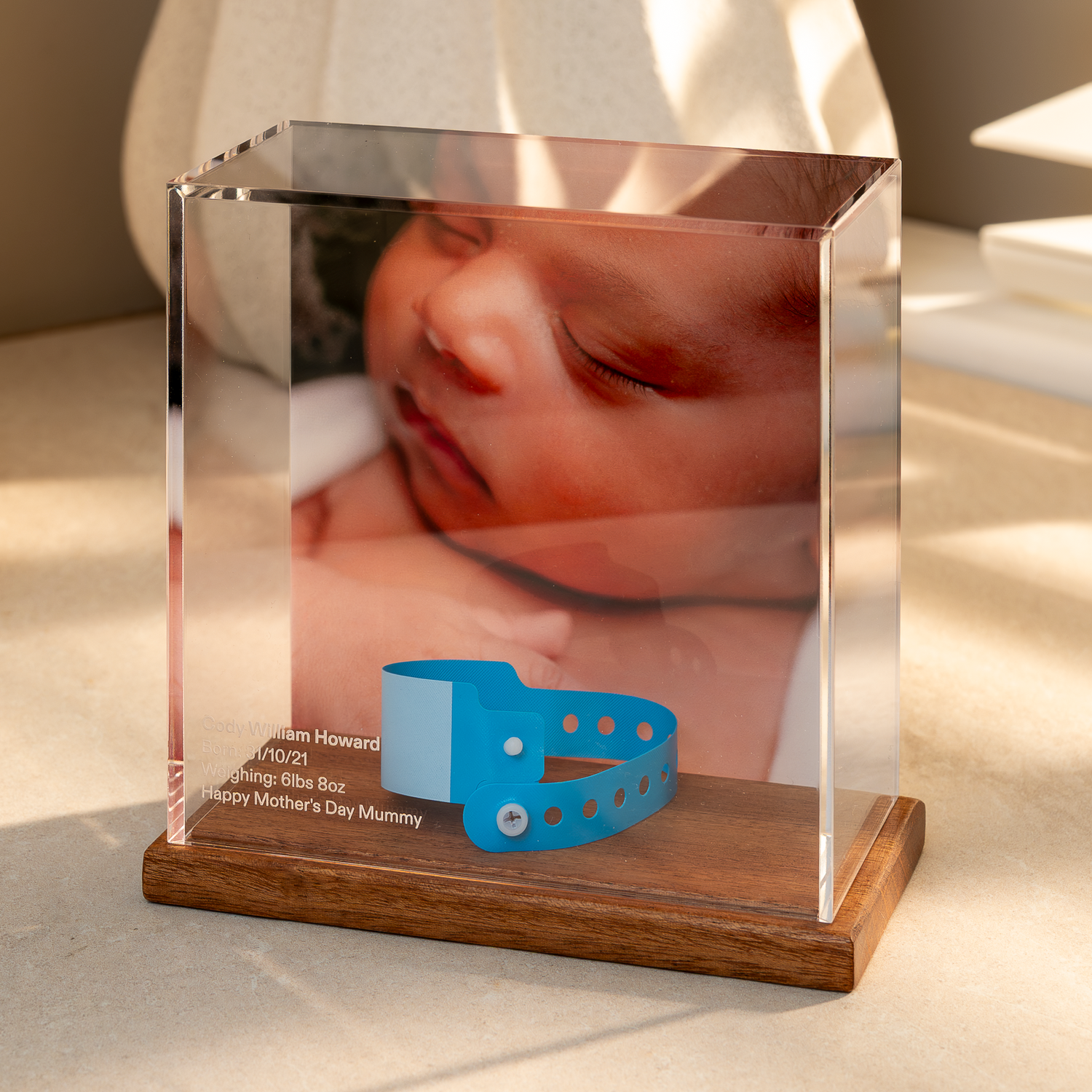 baby Memory Case with Mahogany base displaying a photo of a baby and a baby's hospital wristband